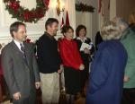 Sean Parnell, left, and Sarah Palin, center, greet visitors to the governor's mansion during a Christmas open house.